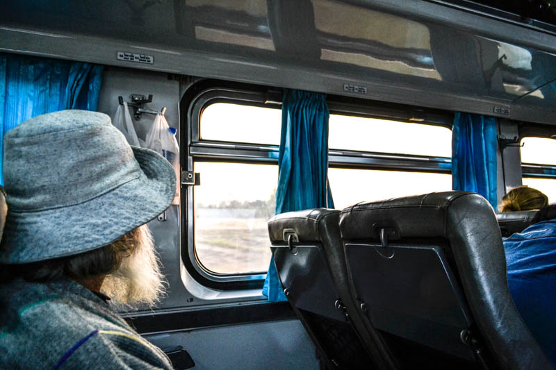 A passenger looks out the window in the train to Chiang Mai. Photo by Melanie van Zyl