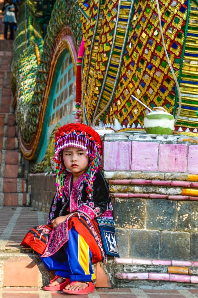 A little Thai girls dressed in traditional garb sits outside one of the many temples in Chiang Mai. Photo by Melanie van Zyl