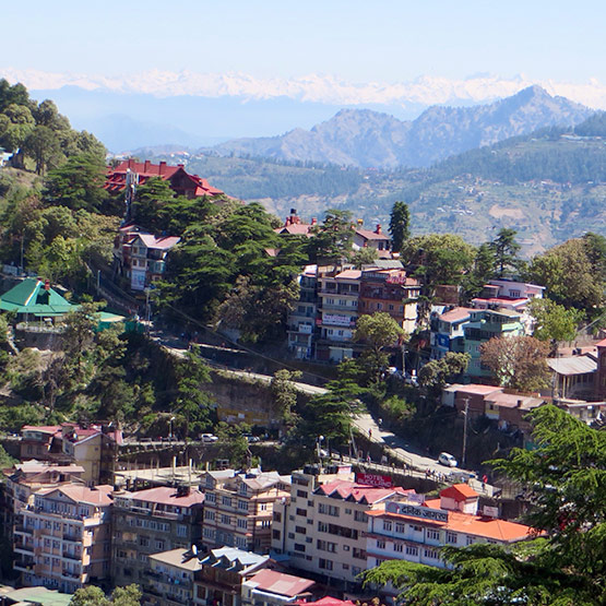 Looking out over Shimla, capital of the north Indian state of Himachal Pradesh, with the snow covered peaks of the Himalayas in the distance.