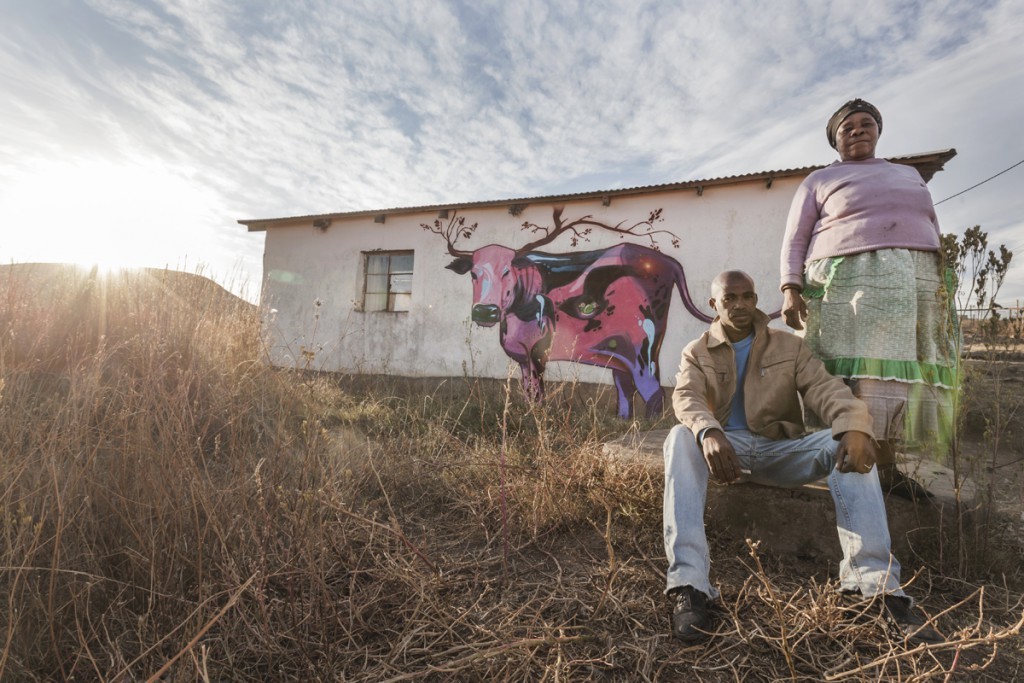 Zukisani Joseph Gimbigimhi sits next to his mother, in front of their newly decorated Mpendla home.