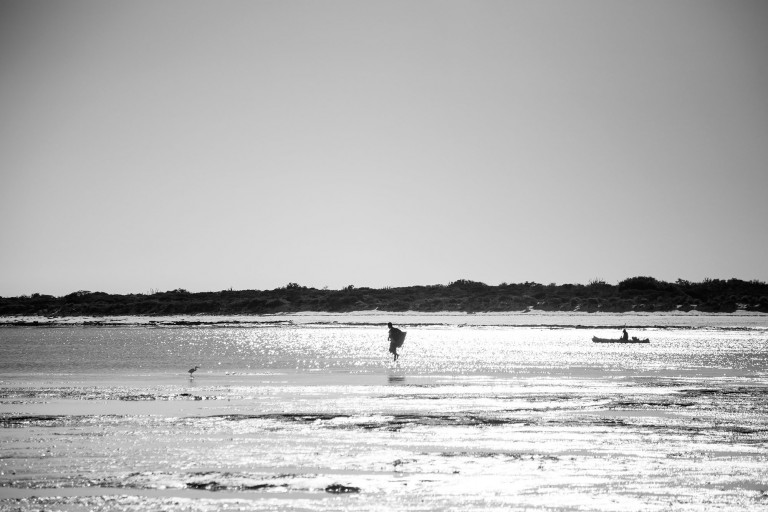 Fisherman at Salary bay walks towards his boat at sunset. 