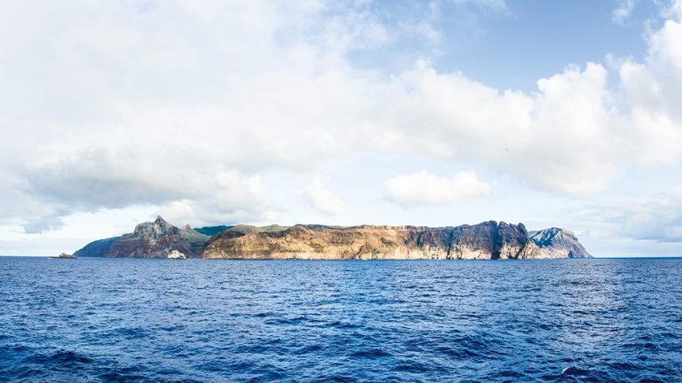 The windward side of St Helena looms on the horizon, a rocky salvation for sailors of days past.