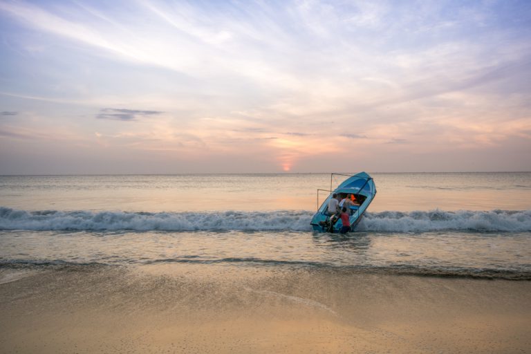 A dive boats heads out on calm waters at sunrise in Trincomalee.