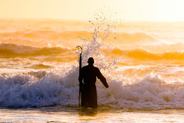 A Zionist walks out into the water in an early-morning cleansing ceremony