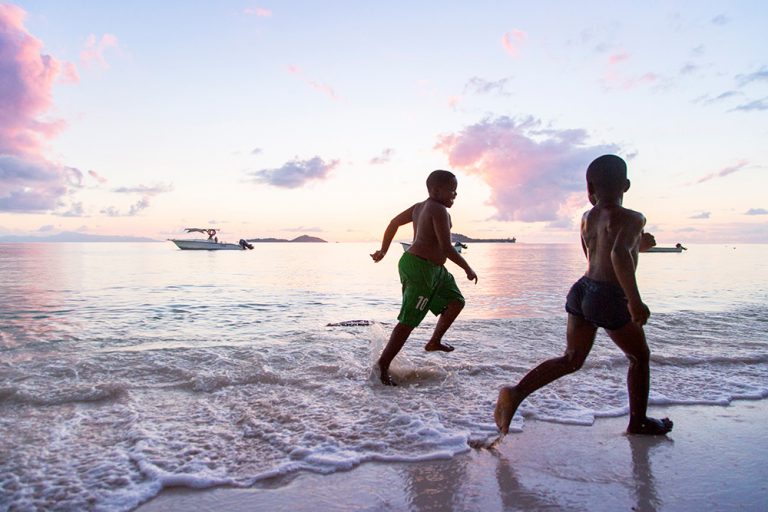 Still evening waters at Anse Kerlan in Praslin. These two boys had helped push out their father's boat for nighttime fishing. 