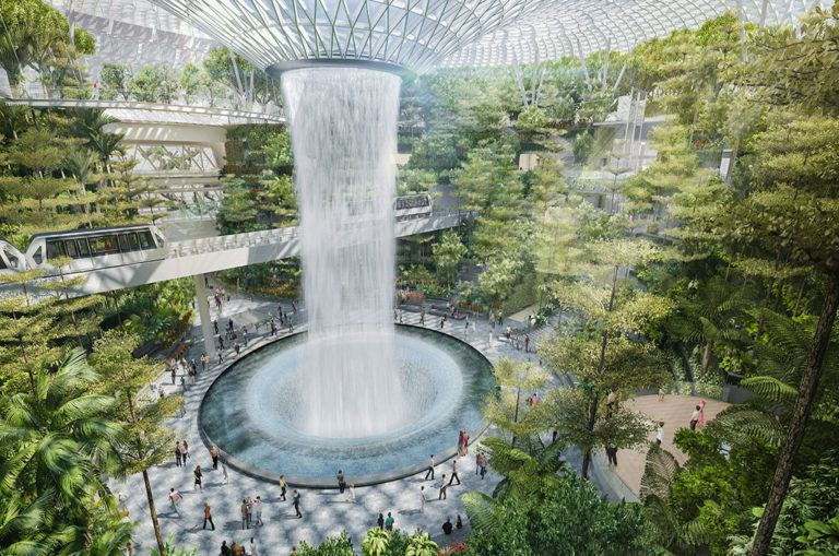 The skytrain passes right by the waterfall and travellers walk by as they explore the complex or make their way to their terminal. Image: Changi Airport Singapore.