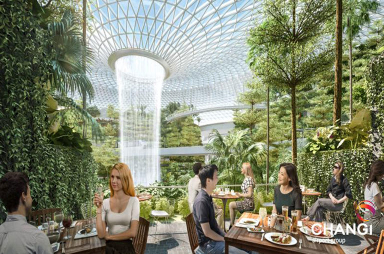 Higher up, restaurants and retail stores look out over the central forest and waterfall. Image: Changi Airport Singapore.