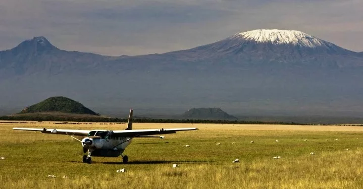 Amboseli National Park elephants, Mount Kilimanjaro Amboseli view, Amboseli safari landscape Kenya, Amboseli flooded airstrip Kenya, Tawi Airstrip Kenya aerial view, Amboseli wildlife safari Kenya, Amboseli plains after rain, Amboseli safari vehicles Kenya, Amboseli elephant herd Kilimanjaro, Kenya safari airstrip travel, East Africa safari destination, Amboseli National Park Kenya scenery, Getaway Magazine