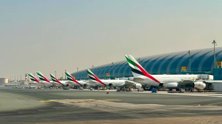 Dubai airport smoke plume, Dubai airport drone incident, DXB airport disruption, Emirates aircraft at Dubai airport, Dubai airport terminal passengers waiting, Dubai skyline smoke near airport, UAE airport security response, Middle East aviation disruption, Dubai International Airport runway activity, Getaway Magazine